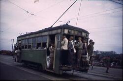市電に鈴なりにぶらさがる人々 / Passengers Holding Grab Handles on a Crowded Tram image
