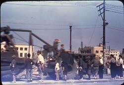 大通りで重機械を見つめる人々 / People Staring at Heavy Machinery on the Main Street image