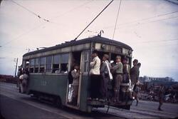 市電に鈴なりにぶらさがる人々 / Passengers Holding Grab Handles on a Crowded Tram image