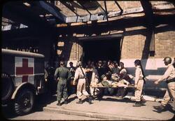 担架で救急車に運ばれる捕虜 / Prisoner of War Being Carried to an Ambulance on a Stretcher image