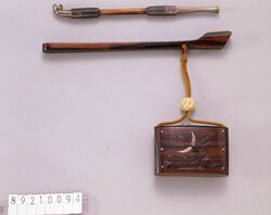波彫弦月象嵌とんこつ腰差したばこ入れ / Tobacco Caddy with Carved Waves and Inlaid Crescent Moon image
