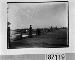 橋の欄干から川面を見下ろす男性 / Man Looking at the River from the Bridge Railing image