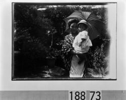 日傘をさして幼児を抱く女性 / Woman Carrying an Infant and Holding a Parasol image