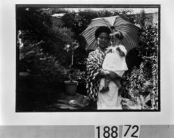 日傘をさして幼児を抱く女性 / A Woman Carrying a Toddler and Holding a Parasol image