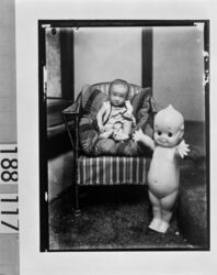 椅子に座る幼児と大きなキューピー人形 / Infant in Chair and Large Kewpie Doll image